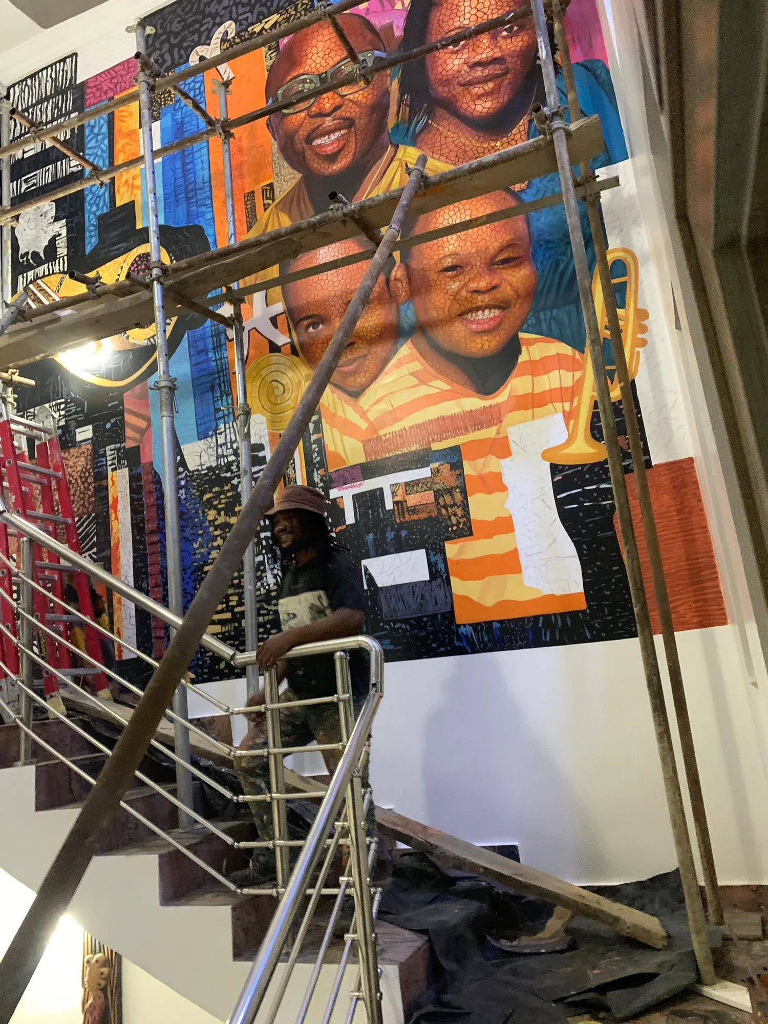Angled view of the Ayẹyẹ mural from the stair landing