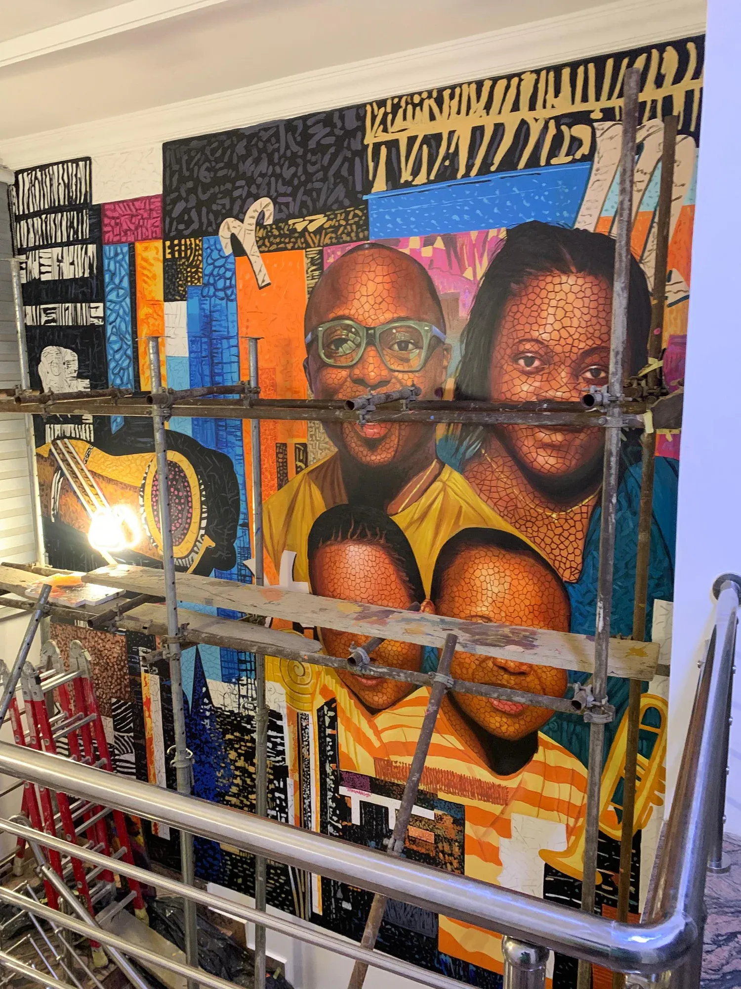 Close detail of faces and layered graphics in the Ayẹyẹ mural