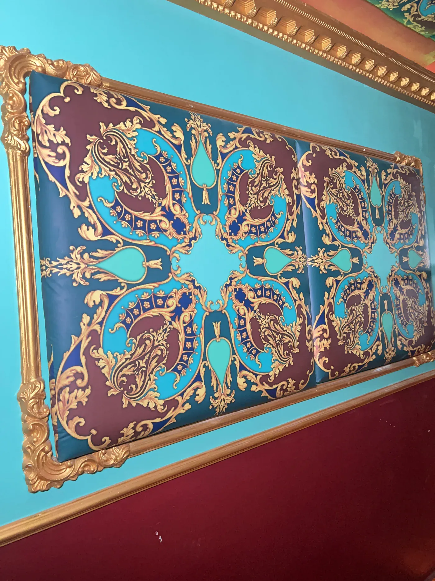 Framed turquoise, burgundy, and gold wall artwork at Club Boho