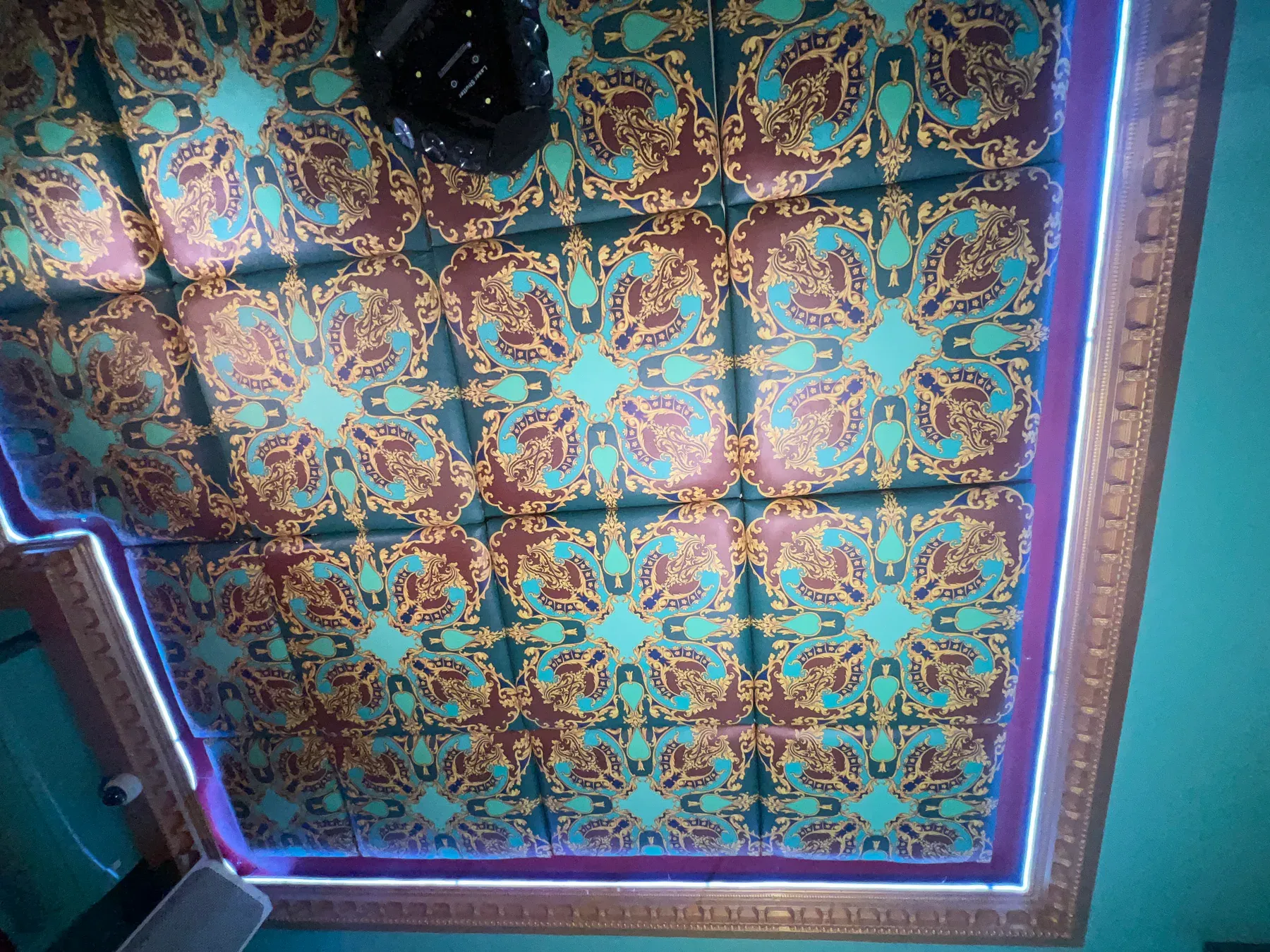 Turquoise, burgundy, and gold patterned ceiling installation in an adjoining Club Boho room