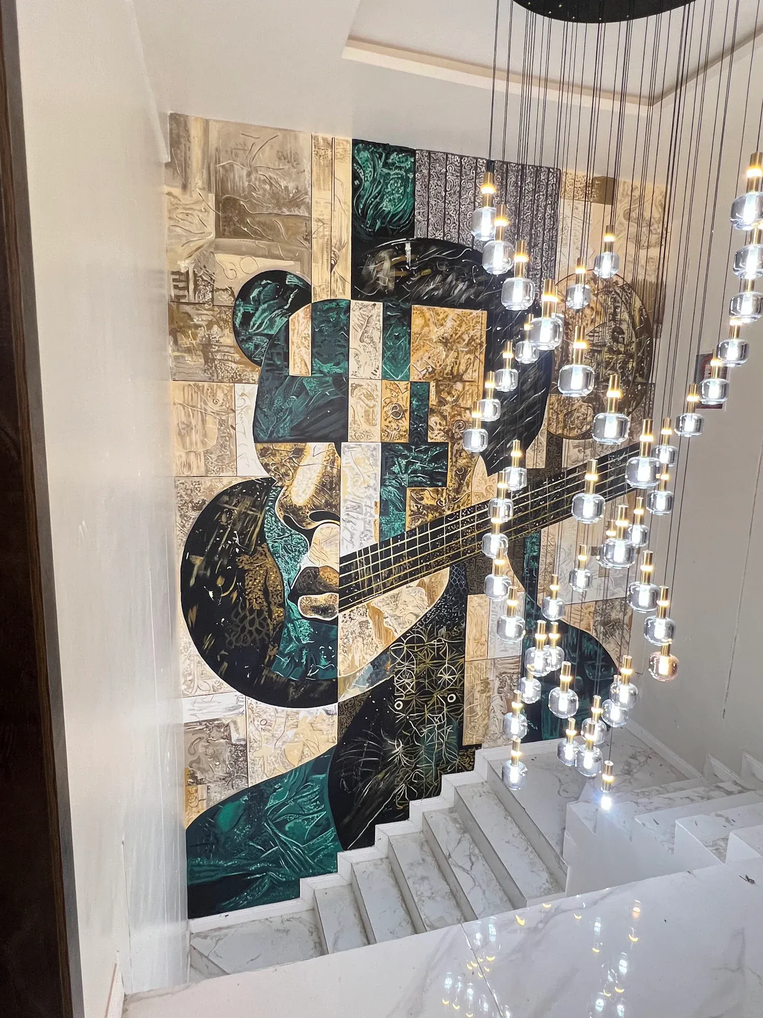 Giran mural viewed with the stairwell chandelier and interior finishes
